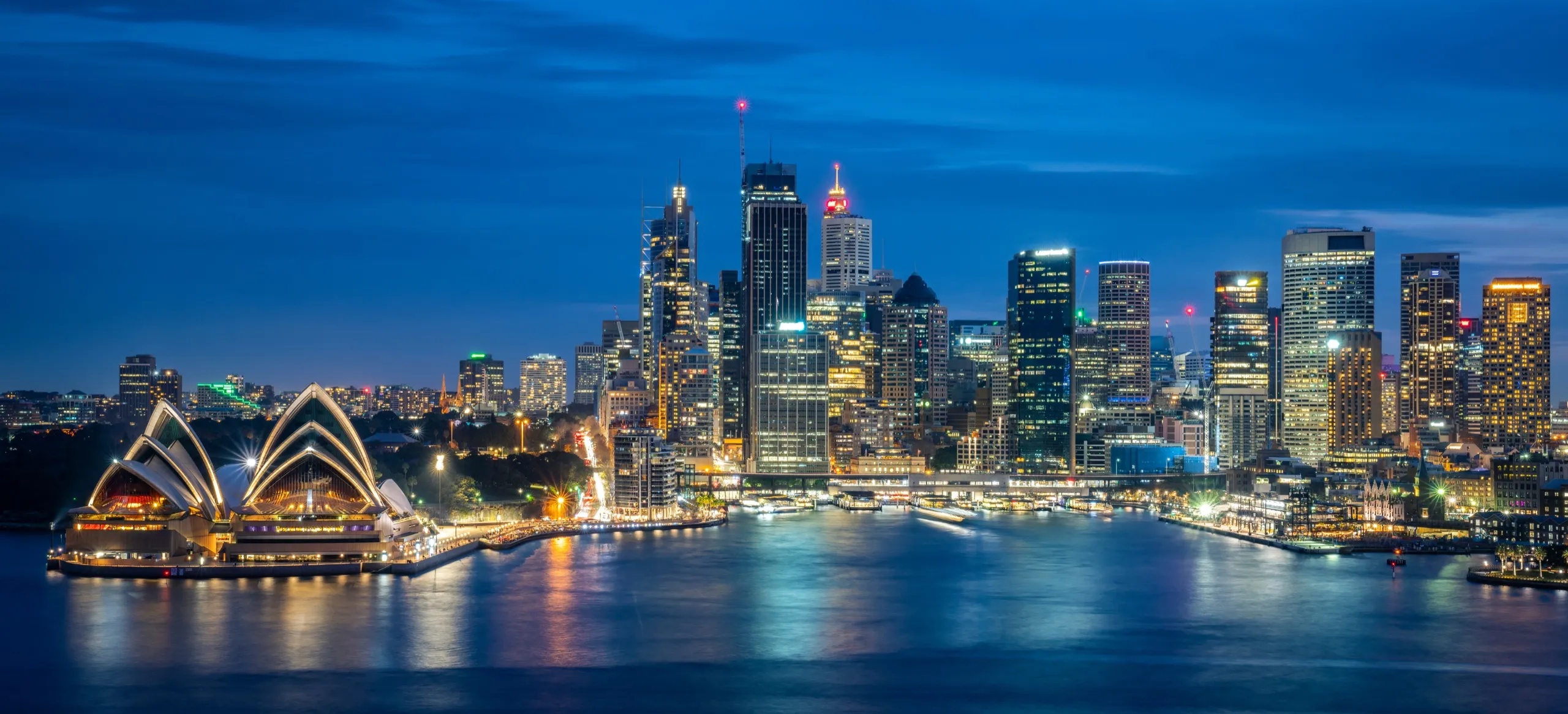 The Sydney CBD skyline and Opera House across Circular Quay at dusk