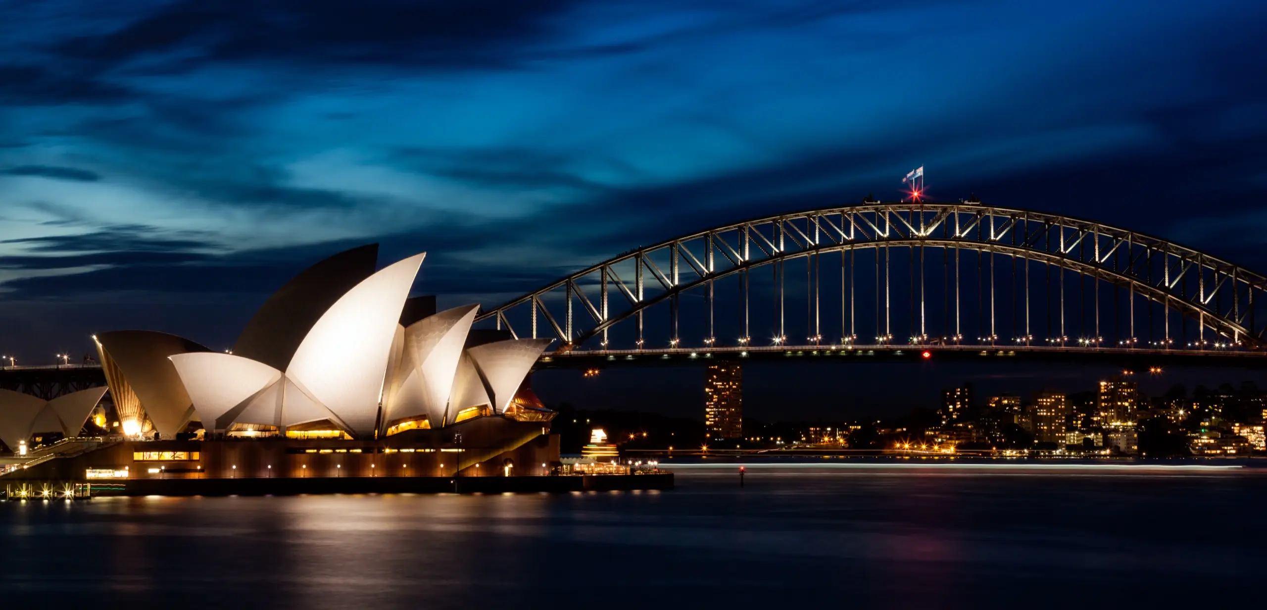 The Sydney Opera House and Harbour Bridge lit at dusk